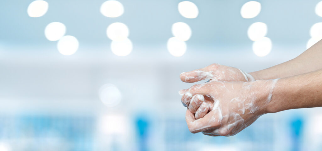 Washes hands to disinfect from the spread of the virus.