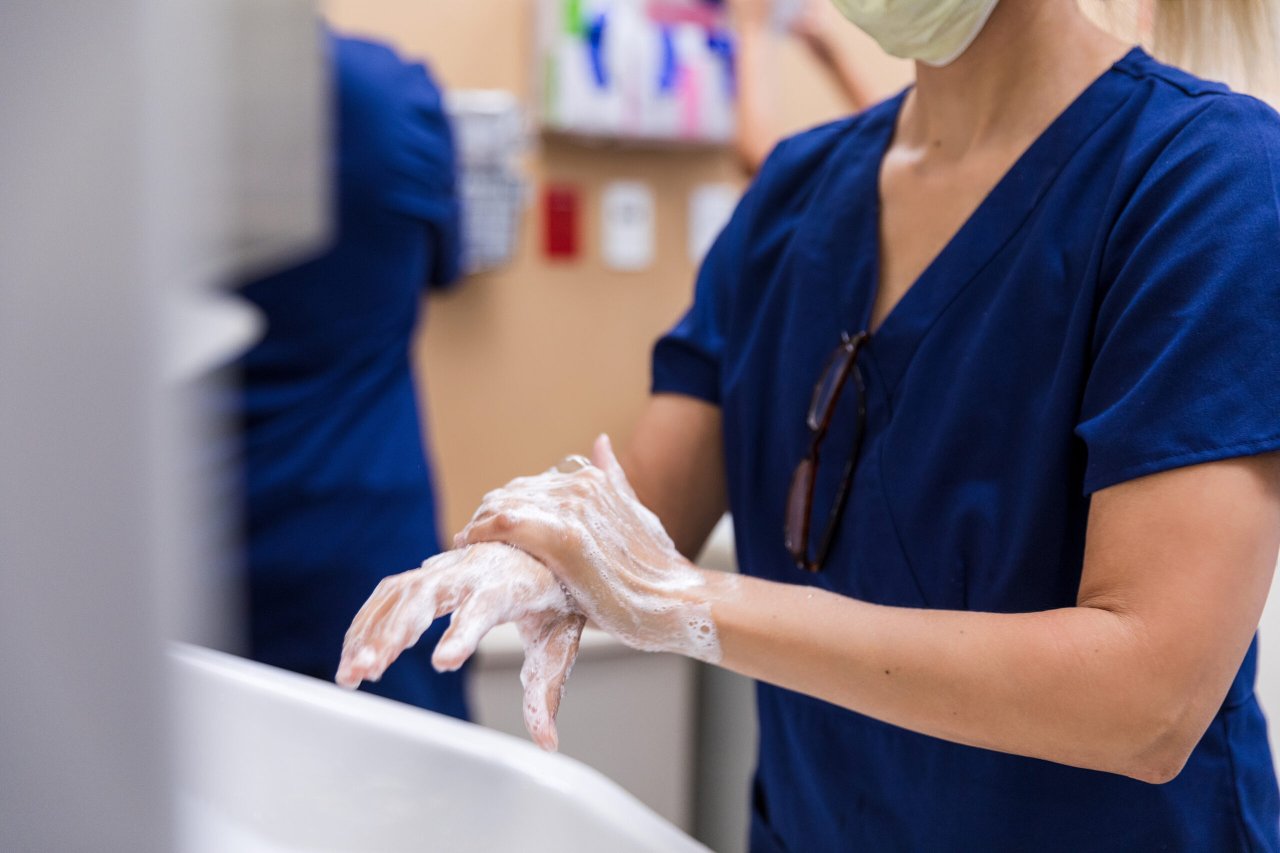 Close-up of a healthcare professional meticulously washing their hands in a medical setting. Hygiene and cleanliness emphasized.